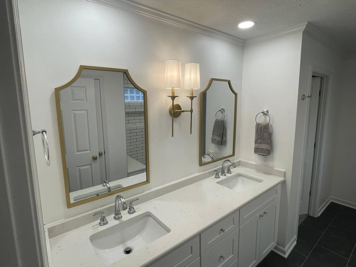 Elegant double vanity bathroom with gold-framed mirrors by Wolfe Construction in Jackson, TN